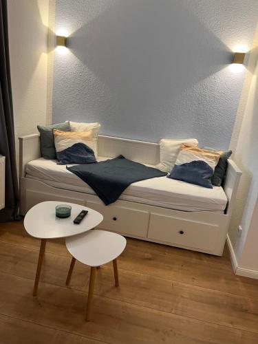 a bed in a room with a table next to it at Lichtermeer in Wilhelmshaven