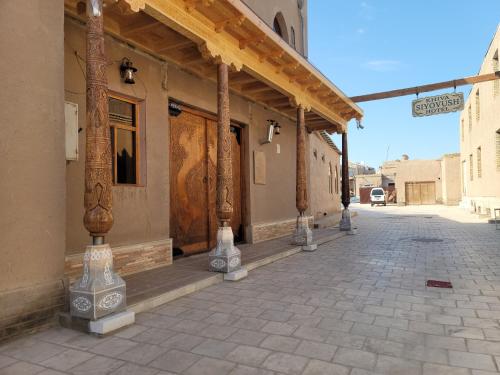 un edificio con columnas en el lateral de una calle en Khiva Siyovush Hotel en Khiva