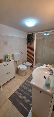 La salle de bains est pourvue d'un lavabo, de toilettes et d'une baignoire. dans l'établissement Ariosto apartment, à Mondragone