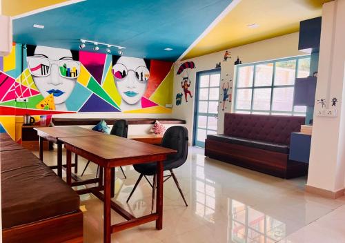 a dining room with a table and a couch at Hotel Starwud Kotagge Dharamshala in Dharmsala