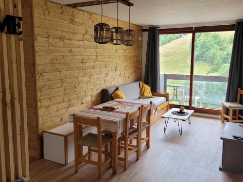 un salon avec une table et un canapé dans l'établissement Le Yéti - Station de ski à pied au Corbier, à Villarembert