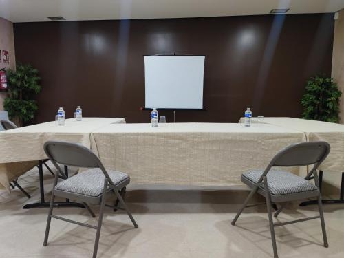 a large table with two chairs and a screen at Hotel Reston Valdemoro in Valdemoro
