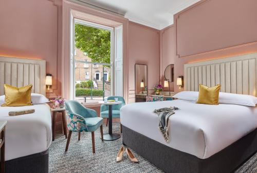 una camera d'albergo con due letti e una finestra di Waterloo Town House & Suites a Dublino
