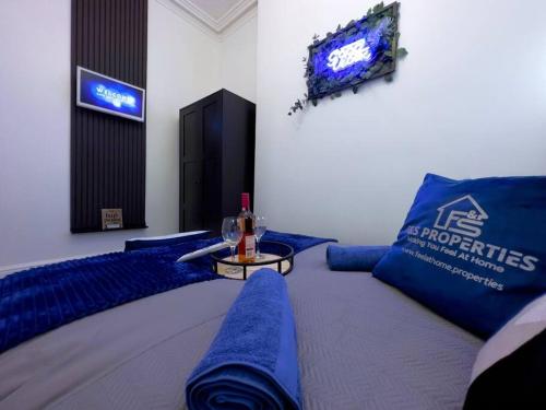 a room with blue pillows and a table with a tv at Swanky Seaside Sanctuary w/ foozeball - Southend in Southend-on-Sea