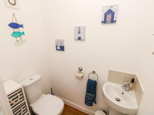 a bathroom with a white toilet and a sink at Tŷ Glas in Bridgend