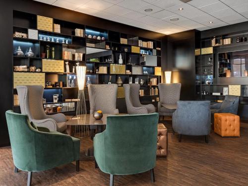 a restaurant with a table and chairs and shelves at Radisson Blu Hotel Dortmund in Dortmund