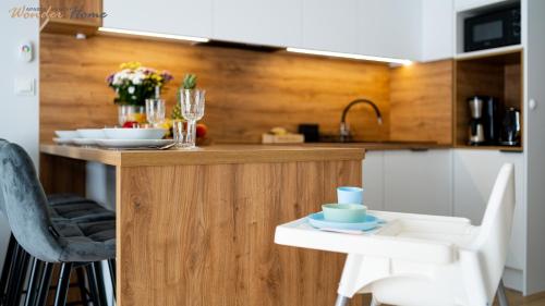 a kitchen with a counter with a table and chairs at Wonder Home - Apartamenty Hillside tuż przy stoku, sklep, plac zabaw i zewnętrzna siłownia na terenie kompleksu in Karpacz