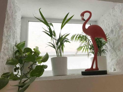 a window sill with plants and a statue of a flamingo at Nice and calm apartment Atocha, Madrid LAC4 in Madrid