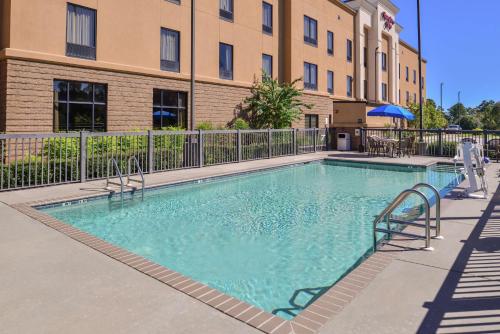 a large swimming pool in front of a building at Hampton Inn Jackson-College Avenue in Jackson
