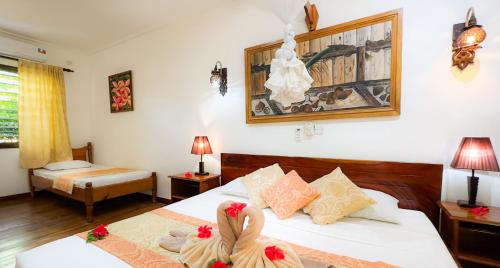 a hotel room with two beds with dolls on them at Cocotier du Rocher in La Digue