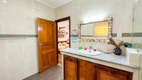 a bathroom with a sink and a mirror at Cocotier du Rocher in La Digue