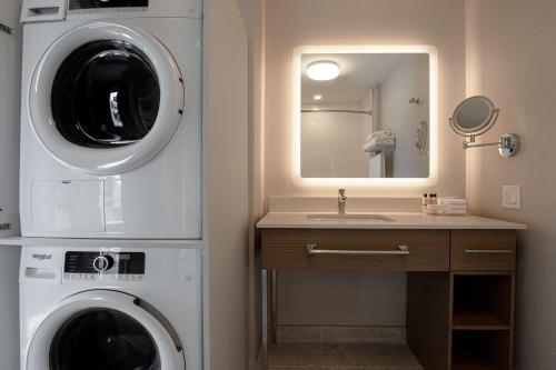 a bathroom with a washing machine and a sink at Hampton Inn Montreal Downtown, Qc in Montréal