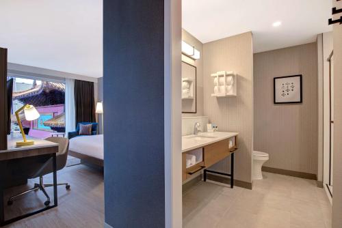 a hotel room with a bathroom with a bed and a sink at Hampton Inn Montreal Downtown, Qc in Montréal