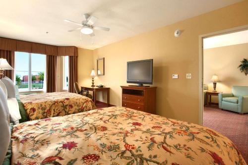 a hotel room with two beds and a flat screen tv at Homewood Suites by Hilton Decatur-Forsyth in Forsyth