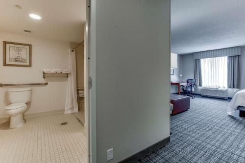 Habitación de hotel con aseo y dormitorio en Hilton Garden Inn Louisville Airport en Louisville
