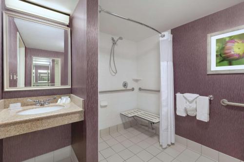 a bathroom with a sink and a shower with a mirror at Hilton Garden Inn Springfield, MA in Springfield