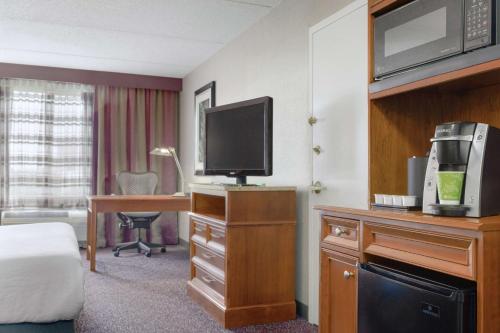 a hotel room with a bed and a desk with a television at Hilton Garden Inn Springfield, MA in Springfield