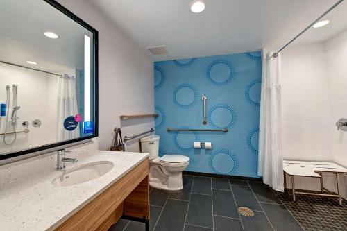 a bathroom with a toilet and a blue wall at Tru By Hilton Tahlequah, Ok in Tahlequah