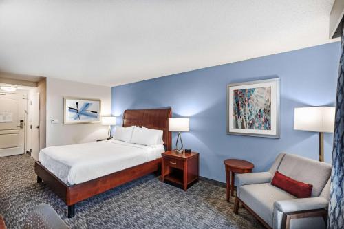 a hotel room with a bed and a chair at Hilton Garden Inn Aiken in Aiken