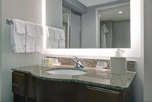 a bathroom with a sink and a mirror at Homewood Suites Charlotte Ayrsley in Charlotte