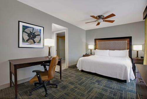 シャーロットにあるHomewood Suites Charlotte Ayrsleyのベッド、デスク、ベッドが備わるホテルルームです。
