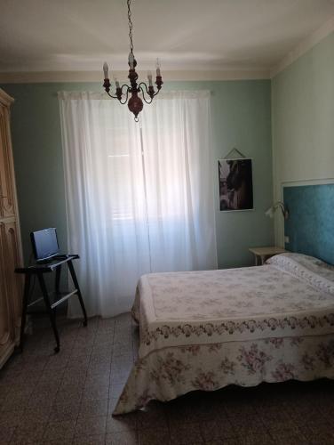 a bedroom with a bed and a window with a laptop at BeB Angelini dal 1911 in Lucca