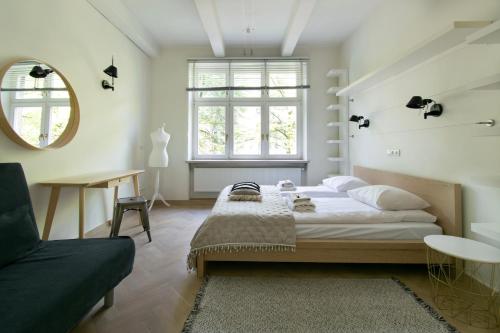 una camera con un letto e una sedia e una finestra di Spacious 3BR apartment with AC in living room, 2 balconies a Cracovia