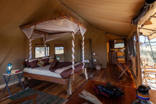 een slaapkamer in een tent met een bed erin bij Mawe Tented Camp in Serengeti