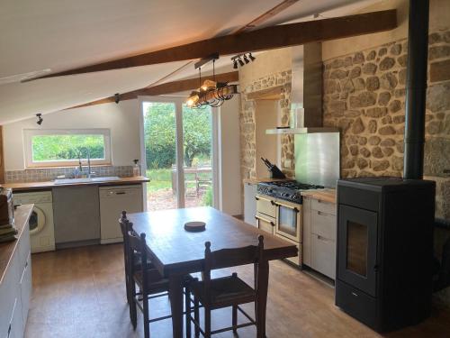 une cuisine avec une table et des chaises dans une pièce dans l'établissement Maison de charme, à Thil-sur-Arroux