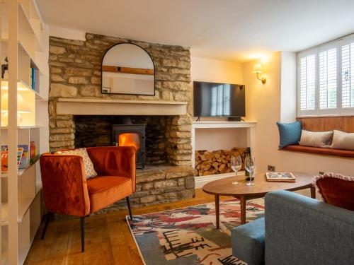 a living room with a stone fireplace at The Roost at Coln in Coln Saint Aldwyn