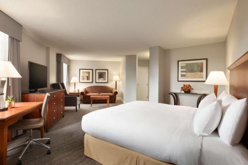 a hotel room with a large white bed and a desk at DoubleTree by Hilton Minneapolis Park Place in Saint Louis Park