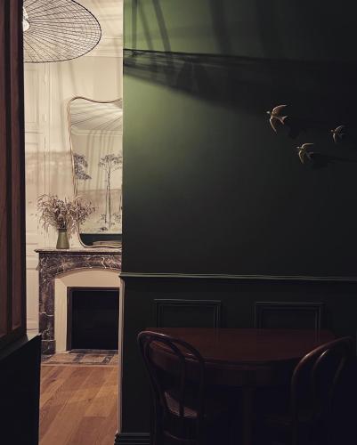 une salle à manger avec une table et une cheminée dans l'établissement Le Grenier à Sel, à Châlons-en-Champagne