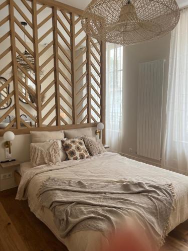 - une chambre avec un grand lit et une grande tête de lit en bois dans l'établissement Le Grenier à Sel, à Châlons-en-Champagne