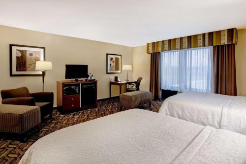a hotel room with two beds and a television at Hampton Inn Dekalb - Near the University in DeKalb