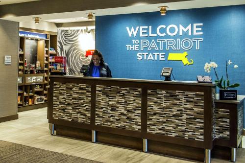 a woman standing behind a counter in a store at Hampton Inn & Suites/Foxborough/Mansfield in Foxborough