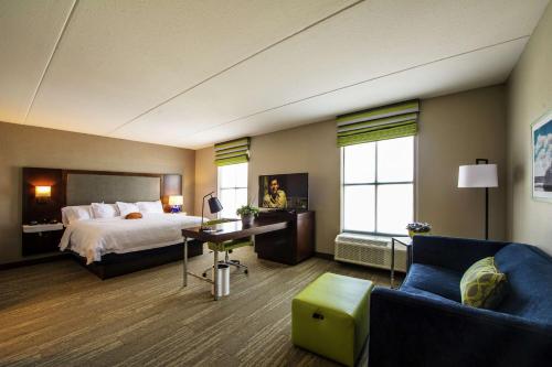 um quarto de hotel com uma cama, uma secretária e uma cadeira em Hampton Inn & Suites/Foxborough/Mansfield em Foxborough