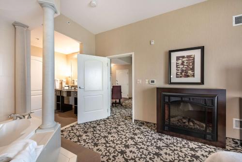 a living room with a fireplace and a bedroom at Homewood Suites by Hilton Oxnard/Camarillo in Oxnard