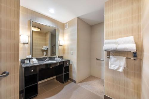 a bathroom with a sink and a mirror and towels at Homewood Suites by Hilton Oxnard/Camarillo in Oxnard