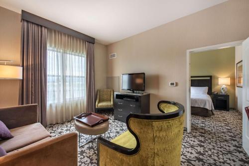 a hotel room with a couch and a bed and a television at Homewood Suites by Hilton Oxnard/Camarillo in Oxnard