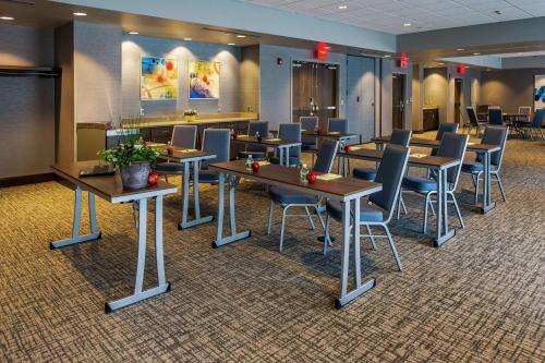 a waiting room with tables and chairs in a hospital at Hampton Inn & Suites/Foxborough/Mansfield in Foxborough