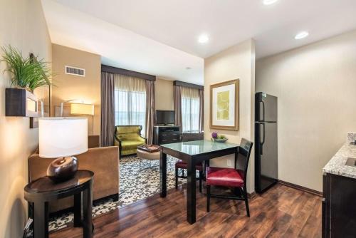 a living room with a table and a kitchen at Homewood Suites by Hilton Oxnard/Camarillo in Oxnard