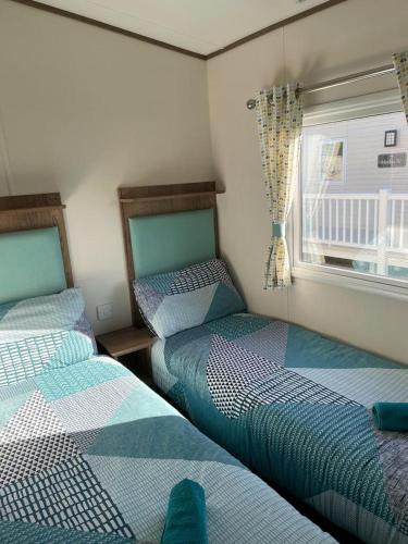 a bedroom with two beds and a window at luxury caravan in Tattershall