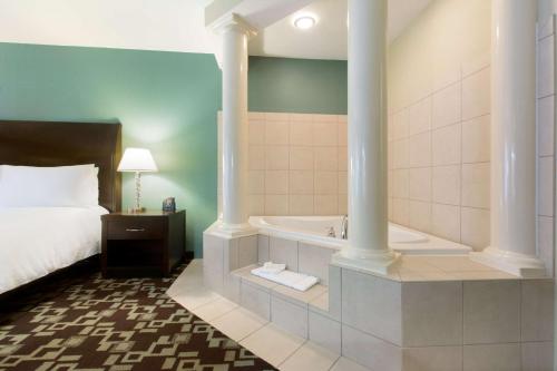 a hotel room with a bed and a bath tub at Hilton Garden Inn Cartersville in Cartersville