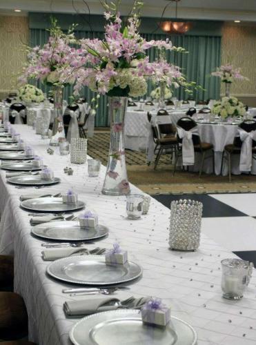 a long table with plates and flowers on it at Hilton Garden Inn Cartersville in Cartersville
