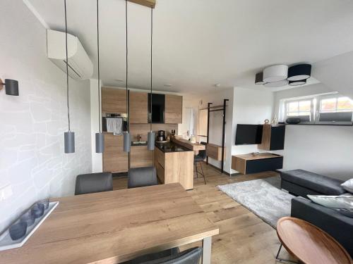 uma cozinha e sala de estar com uma mesa e um sofá em Winkelschiffchen III mit Sauna em Juist