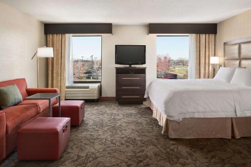 a hotel room with a bed and a flat screen tv at Hampton Inn & Suites Detroit Sterling Heights in Sterling Heights