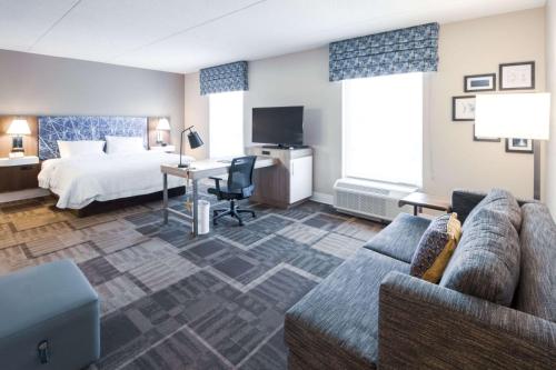 una camera d'albergo con letto e divano di Hampton Inn & Suites Huntsville Hampton Cove a Huntsville