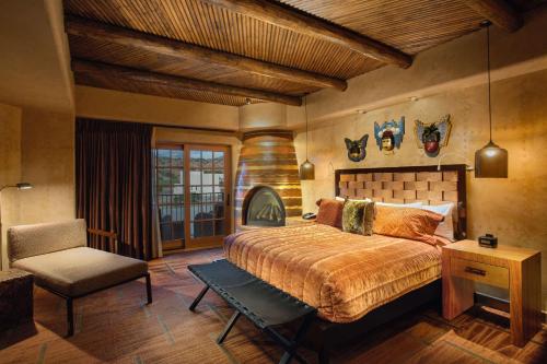 a bedroom with a bed and a chair at Hilton Santa Fe Buffalo Thunder in Santa Fe