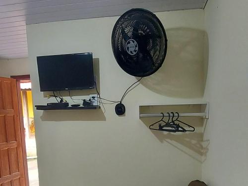 een kamer met een televisie en een ventilator aan de muur bij Recanto Casa Amarela de São Romão in Nova Friburgo