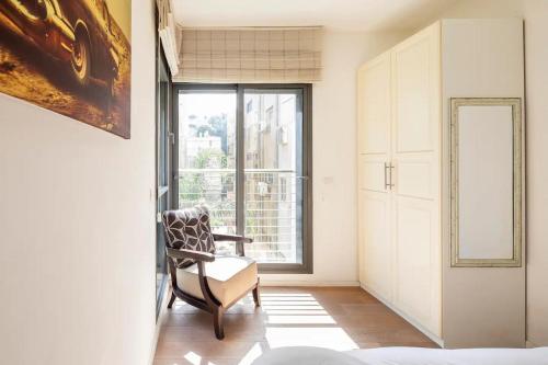 - un salon avec une chaise et une fenêtre dans l'établissement Luxury Oasis Tel Aviv Beach, à Tel Aviv